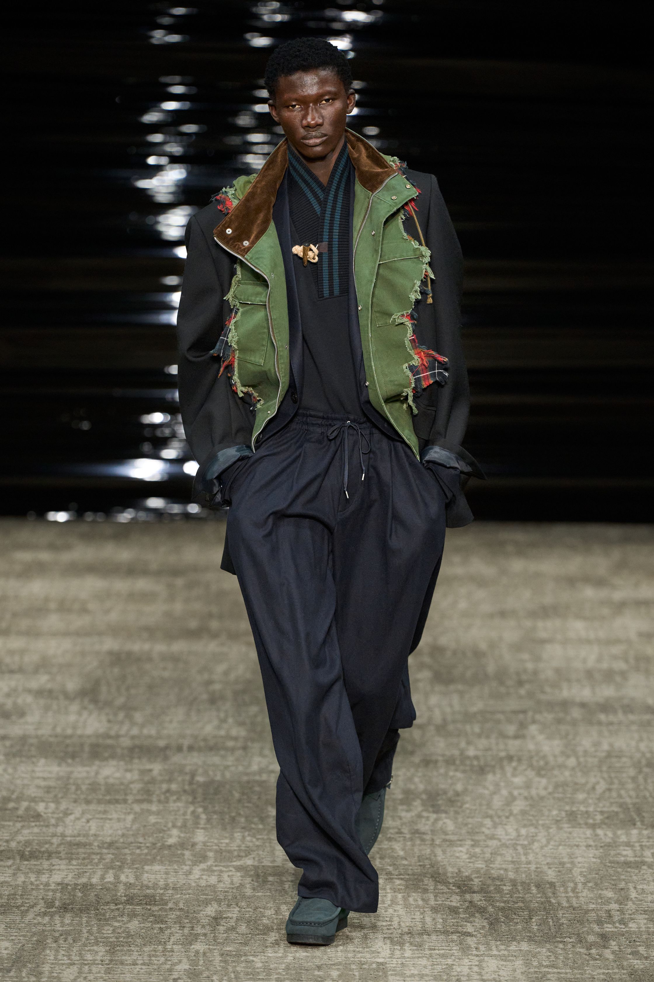 Kolor 26FW 在安静中完成高难度结构表达。层叠、错位、混材质成为视觉主线，运动、正装与工装被精准缝合，却不显拼贴痕迹。色彩克制、比例讲究，服装在行走间展现微妙动态。Kolor 的价值不在“第一眼冲击”，而在长期穿着中逐渐显露的结构智慧，是典型为成熟审美者准备的高完成度男装-顽石频道趋势研究